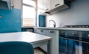 Una cocina con encimera blanca, estufa y lavabo.