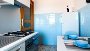 A kitchen with a stove, oven, and a refrigerator. - Fly by Suites Pescara (Pescara)