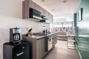 A modern kitchen with a built-in stove, coffee machine, and a compact refrigerator. - The Modern Loft Reforma (Mexico City)