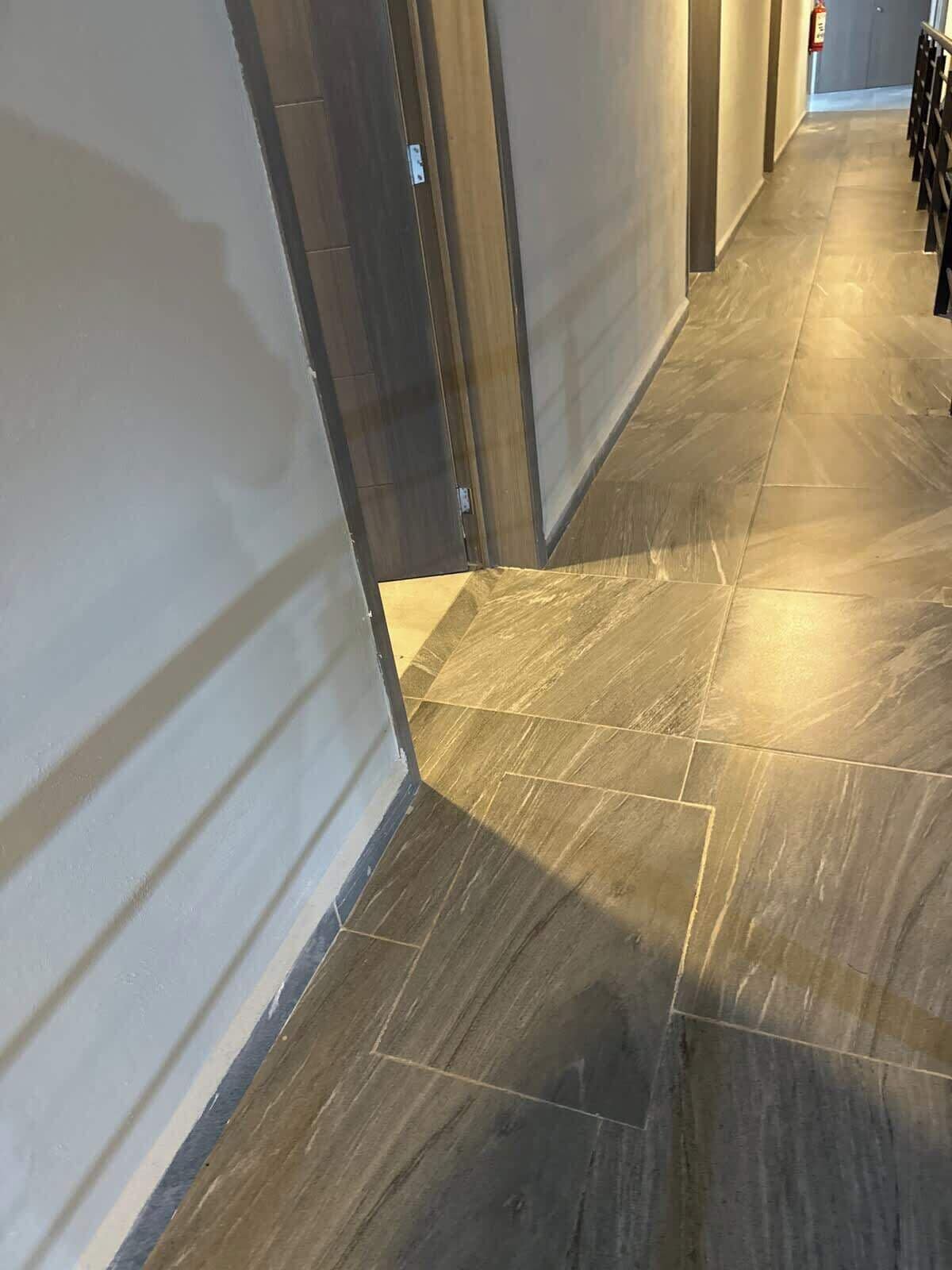 Un pasillo con suelo de baldosas y una puerta a la izquierda.