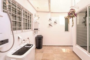 A compact room with a window, a radiator, a trash bin, and decorative wall art. - Cozy and centrally located near Polanco (Mexico City)