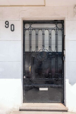 A black metal gate with a decorative design, a number '90' above it, and a metal plate with 'LARAS' on the door. - Cozy and centrally located near Polanco (Mexico City)