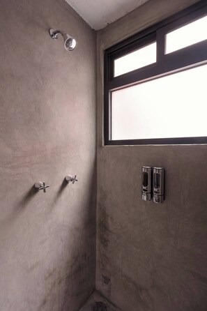 Ein Badezimmer mit Dusche, Fenster und Handtuchhalter.