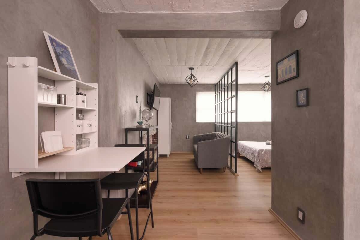 Een modern interieur met een eethoek, een bank en een bed op de achtergrond.