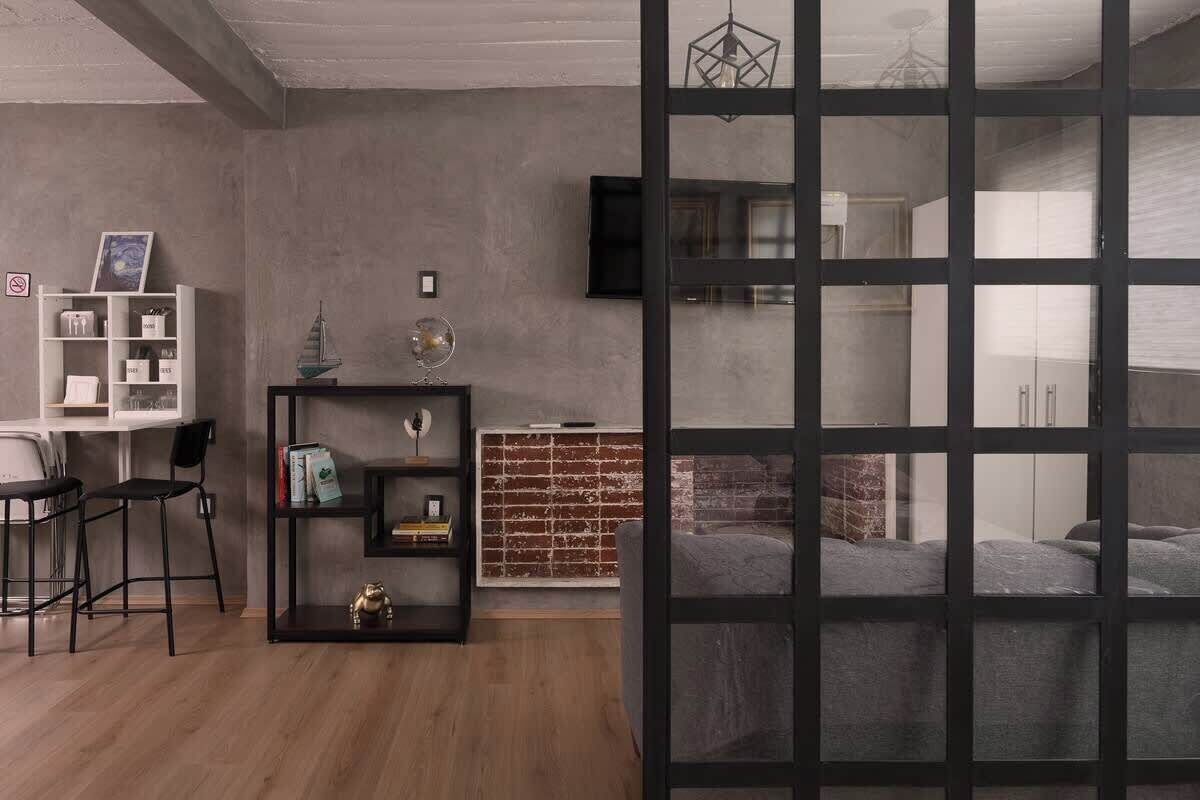 A modern living room with a bookshelf, a fireplace, and a TV mounted on the wall.
