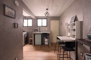A compact kitchen with a dining area, a washing machine, and a small refrigerator. - Nice & Cozy loft near to Reforma (Mexico City)