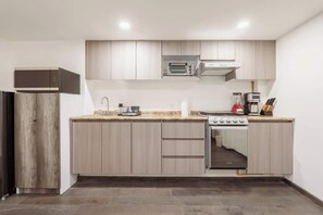 Eine moderne Küche mit eingebautem Backofen, Mikrowelle und Kaffeemaschine.