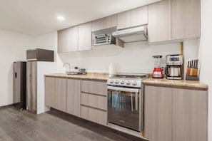 A modern kitchen with a built-in oven, a microwave, and a coffee maker. - The Nice & Cozy Urban Green Haven (Ciudad de México)
