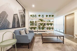 Ein modernes Wohnzimmer mit Sofa, Couchtisch und einer an der Wand befestigten Pflanzenablage.