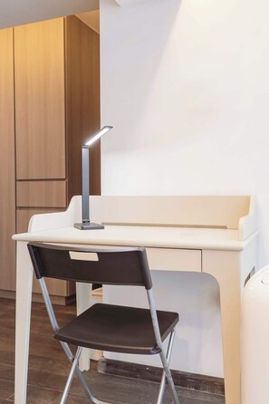 Ein moderner Arbeitsplatz mit Schreibtisch, Stuhl und verstellbarer Schreibtischlampe.