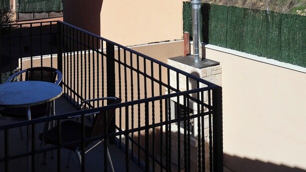 A terrace with a table and chairs, a view of a historic fort, and a parked car. - Country Villa Puerta del Gallo (Molina de Aragón–Alto Tajo) (Molina de Aragón)