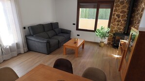 A living room with a sofa, a coffee table, a dining table, and a fireplace. - Country Villa Puerta del Gallo (Molina de Aragón–Alto Tajo) (Molina de Aragón)
