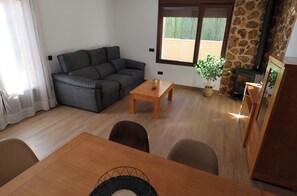 Un salon comprenant un canapé, une table basse, une table à manger et une cheminée.