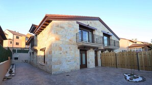 A stone house with a balcony, a wooden fence, and a paved courtyard. - Country Villa Puerta del Gallo (Molina de Aragón–Alto Tajo) (Molina de Aragón)