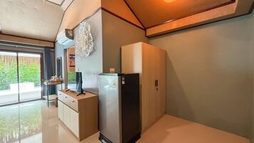 Eine moderne Küche mit einem eingebauten Kühlschrank, einem Holzschrank und einer Deckenleuchte.
