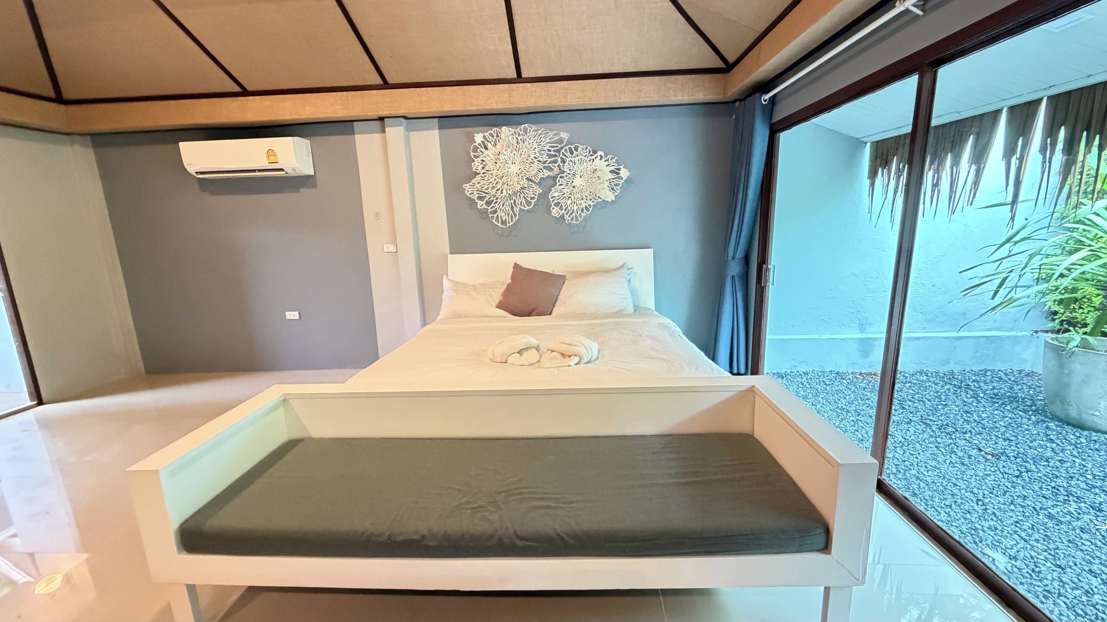 Una habitación de hotel moderna con una cama, un elemento decorativo en la pared y vistas al exterior.