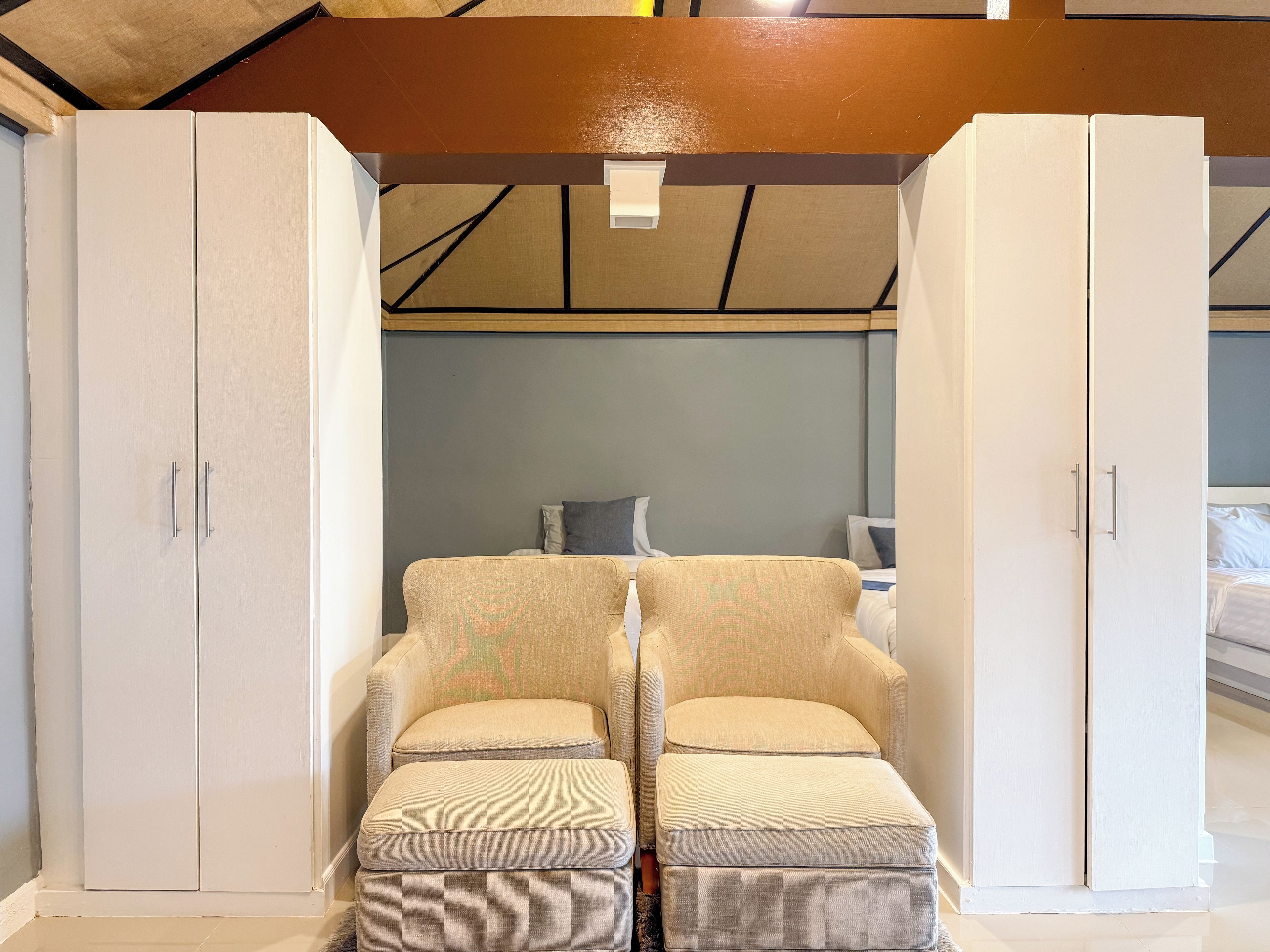 Una habitación con cama, una silla y un armario.