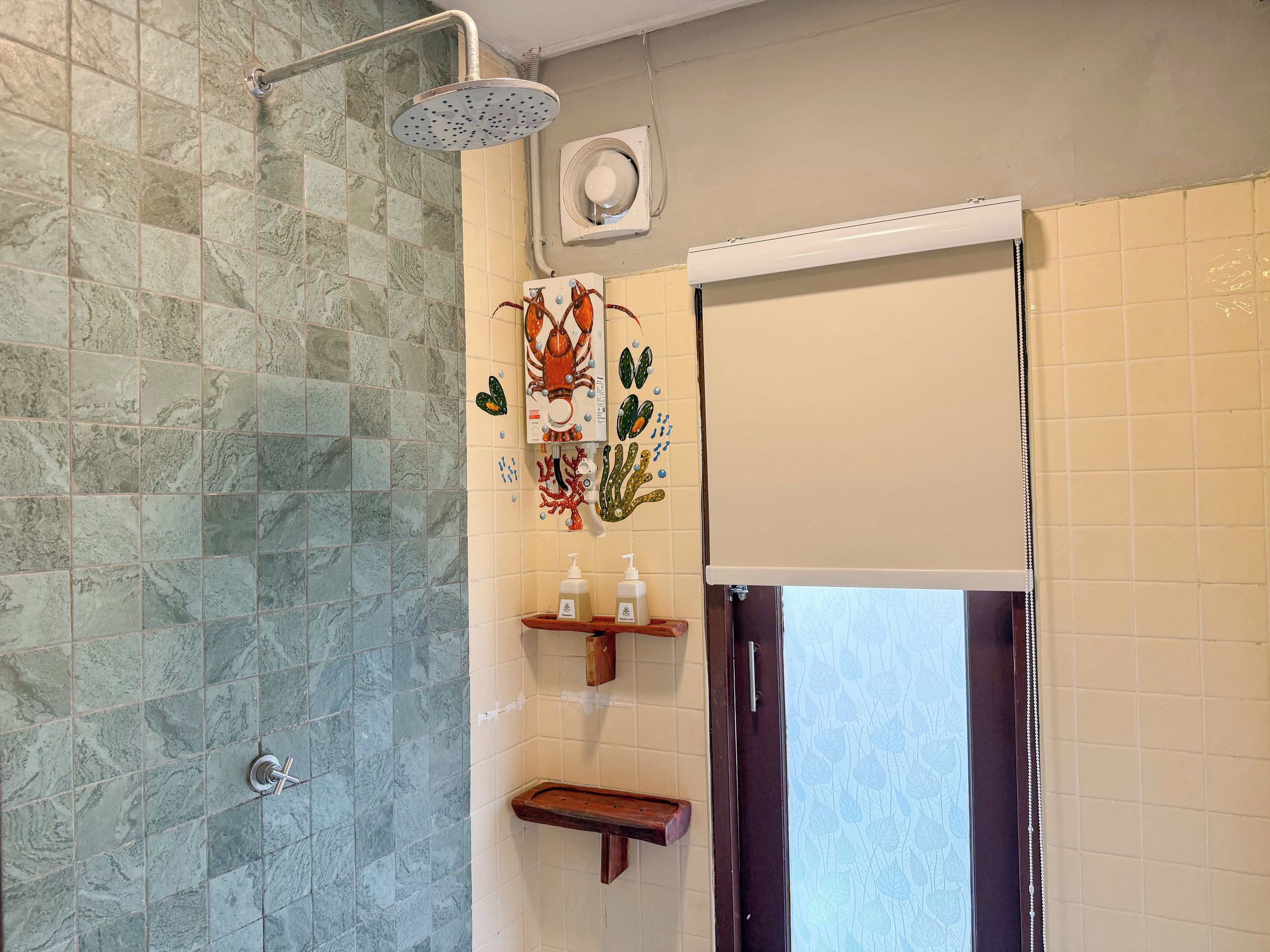 A bathroom with a shower, a toilet, and a sink with a decorative coral mural.