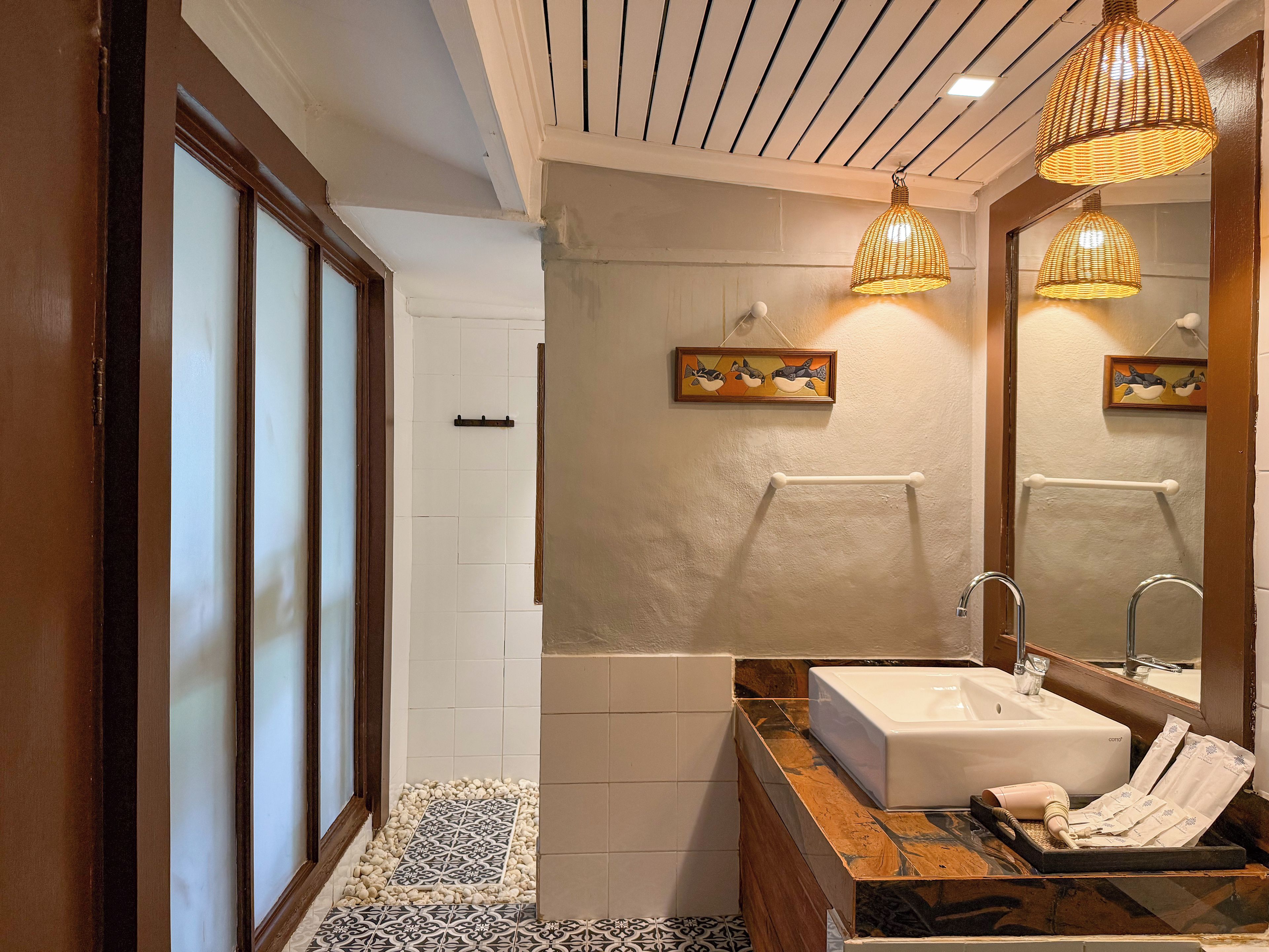 Un baño con un espejo grande, un lavabo y una zona de ducha.