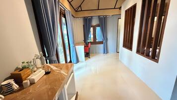 A corridor with a marble counter, a red chair, and a window with curtains.