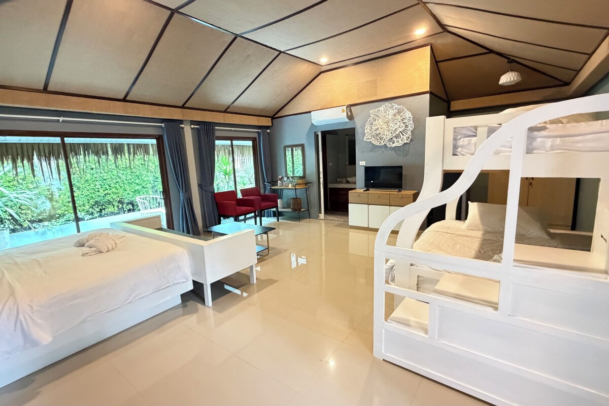 A modern hotel room with a bunk bed, a desk, a chair, and a TV.