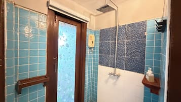 Une salle de bain avec une douche, des toilettes et un lavabo.