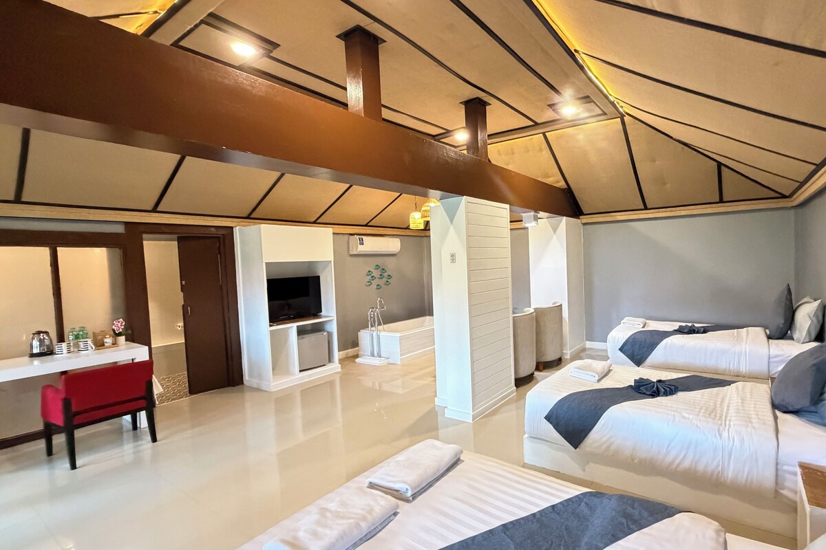 A modern hotel room with a large bed, a desk, and a TV.