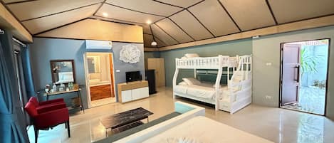Una habitación de hotel moderna con una cama nido, un escritorio con silla, un tocador con espejo y una cama grande con una toalla doblada con cuidado.