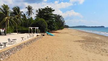 On the beach, black sand, beach umbrellas, beach towels