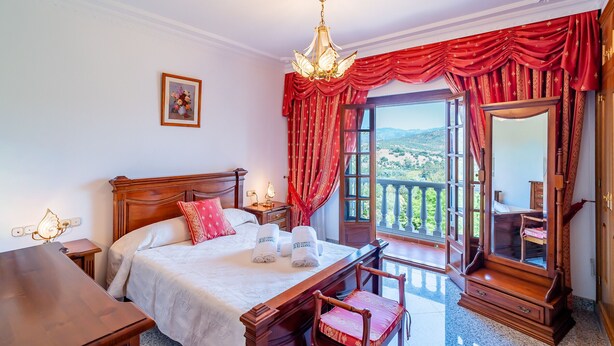 A bedroom with a bed, bedside table, lamp, and a view of the outdoors. - Cubo's Paraje Galiano Rural House / Private pool / BBQ / Free Wi-Fi (Guaro)
