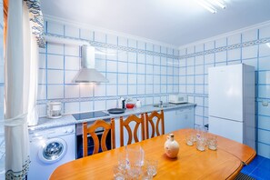 A compact kitchen with a dining table, chairs, a microwave, a kettle, and a refrigerator. - Cubo's Paraje Galiano Rural House / Private pool / BBQ / Free Wi-Fi (Guaro)