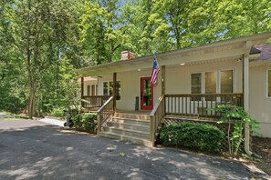 Ein eingeschossiges Gebäude mit Veranda, einer roten Tür und einer amerikanischen Flagge.