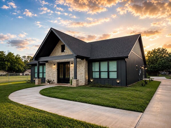 A modern house with a stone exterior, a sloped roof, and a large front porch.