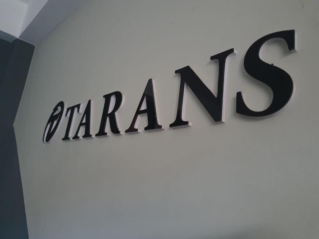 Uma parede com a palavra 'TARANS' em letras grandes e negrito.
