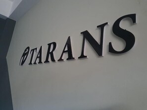 Una pared con la palabra 'TARANS' escrita en letras grandes y negritas.