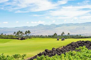 A golf course with a view of distant mountains and palm trees. - Mauna Lani Villa | Pool, Spa, Golf Views, Beach Club & Golf Cart Included (Waimea)