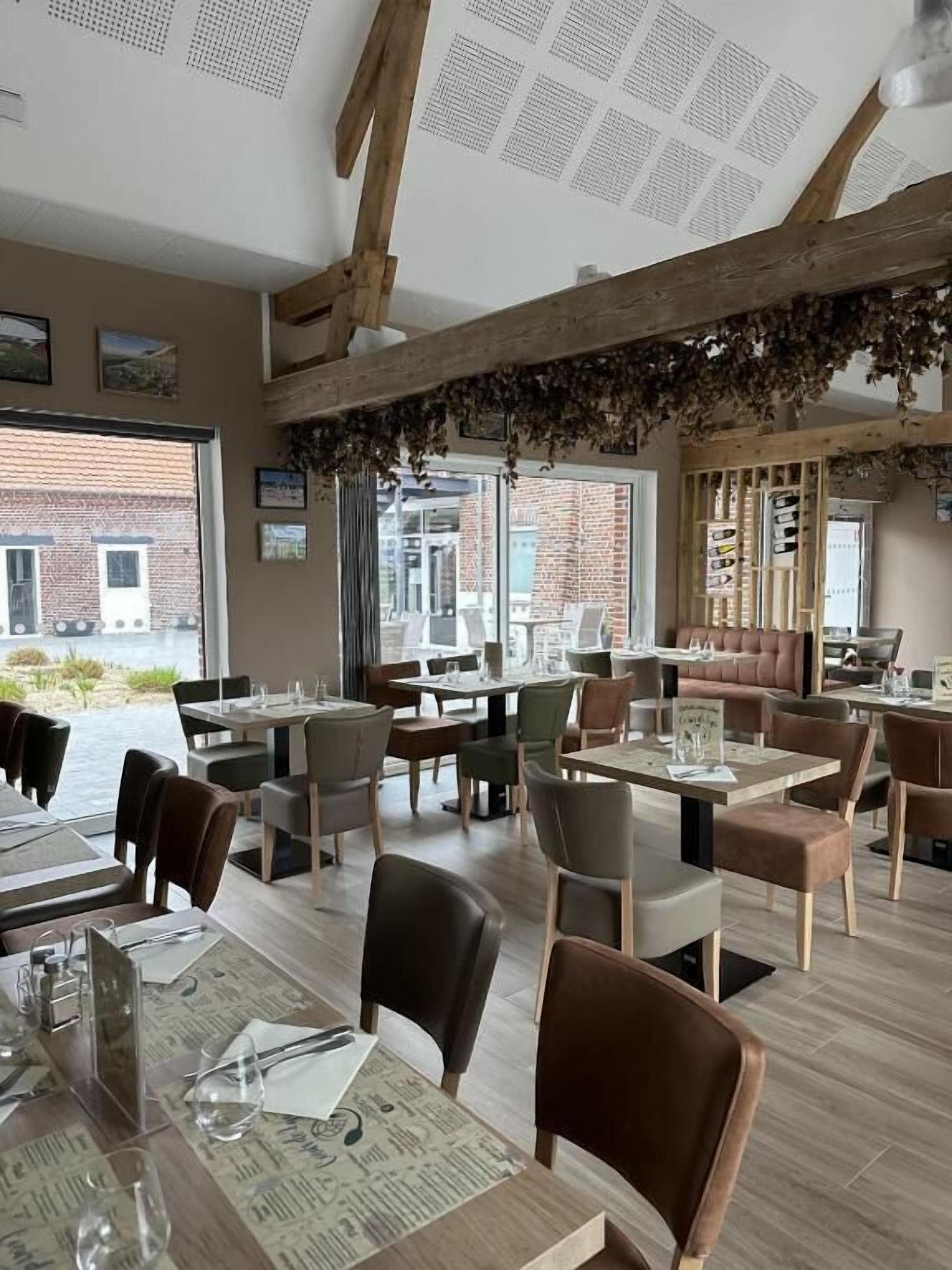 Een restaurant met houten balken, tafels met menukaarten en stoelen.