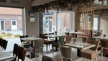 Een restaurant met houten balken, tafels met menukaarten en stoelen.