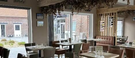 A restaurant with wooden beams, tables with menus, and chairs.