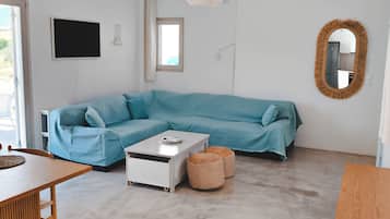 Una sala de estar moderna con un sofá seccional, una mesa de centro y un comedor con mesa y sillas.