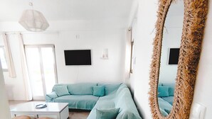 Ein modernes Wohnzimmer mit Ecksofa, Couchtisch und einem großen Spiegel.