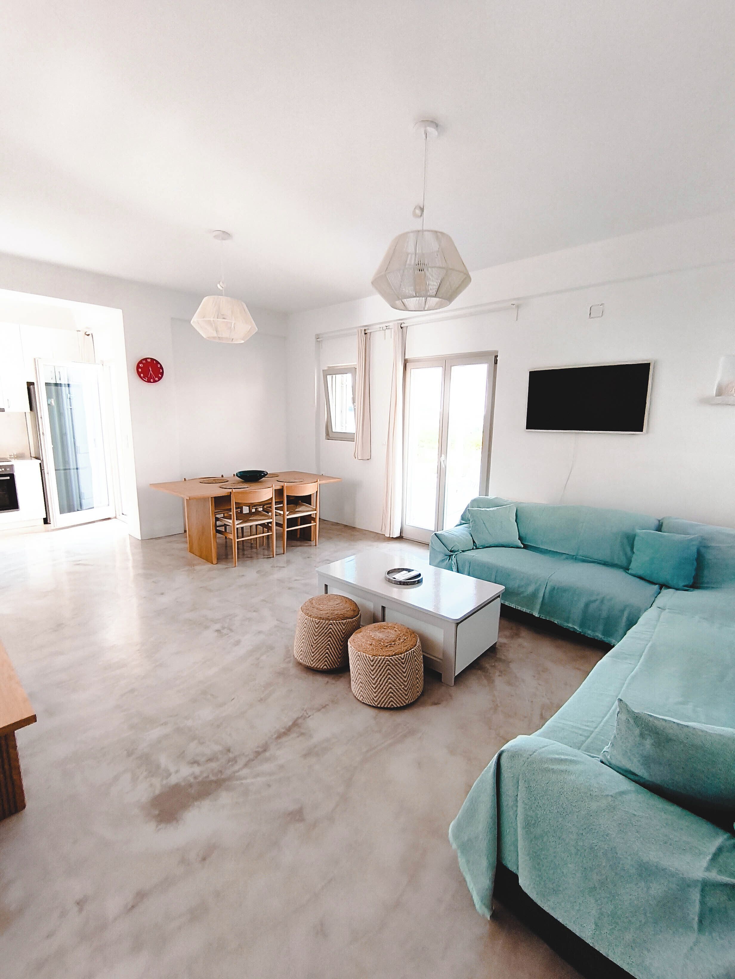 A spacious living area with a sofa, coffee table, and dining table.