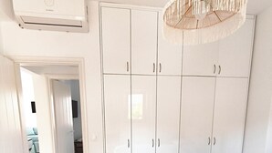 Ein Schlafzimmer mit Bett, Kleiderschrank und Klimaanlage.