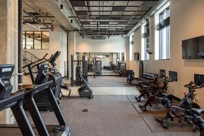 A gym with treadmills, elliptical machines, and weight equipment. - Sleepover | Urban Studio + Gym/Sauna - Omaha (Omaha)