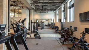 A gym with treadmills, elliptical machines, and weight equipment. - Sleepover | Airy Studio + Gym/Sauna - Omaha (Omaha)