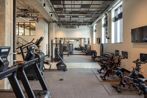 A gym with treadmills, elliptical machines, and weight equipment. - Sleepover | Airy Studio + Gym/Sauna - Omaha (Omaha)