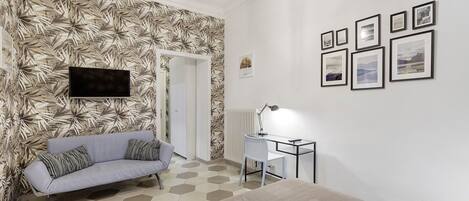 A modern bedroom with a sofa, a desk, and a bed.