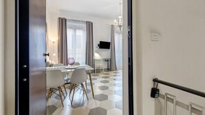 Hotellihuone, jossa on ruokailutila, televisio ja kattokruunu.