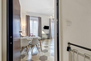 Ein Hotelzimmer mit Essbereich, Fernseher und einer Chandelüster.