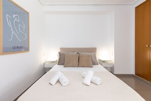 A bedroom with a bed, pillows, a bedside table, a nightstand, a wooden wardrobe, and a framed artwork on the wall. - Patacona Pure. WiFi+PK+A/C+Pool (Alboraya / Alboraia)